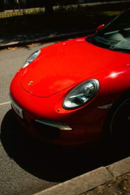 Chiswick London UK 2025.07.11 Viktorya tarzı kırmızı tuğla bir evin önünde park etmiş beyaz Morris Minor 'un koyu pencereli ve yeşil yapraklı görüntüsü.