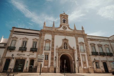 Algarve, Portekiz 2025.06.28 Pembe tişörtlü yaşlı bir adam Algarves 'in göbeğindeki mozaik kaplı bir alışveriş sokağının gölgesinde oturuyor.             