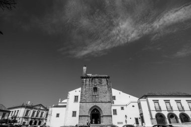 Algarve, Portekiz 2025.06.28 Pembe tişörtlü yaşlı bir adam Algarves 'in göbeğindeki mozaik kaplı bir alışveriş sokağının gölgesinde oturuyor.             