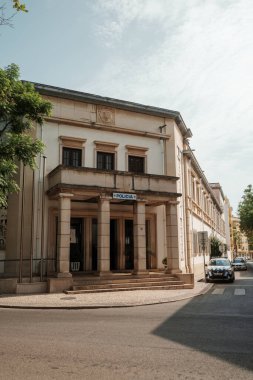 Algarve, Portekiz 2025.06.28 Pembe tişörtlü yaşlı bir adam Algarves 'in göbeğindeki mozaik kaplı bir alışveriş sokağının gölgesinde oturuyor.             