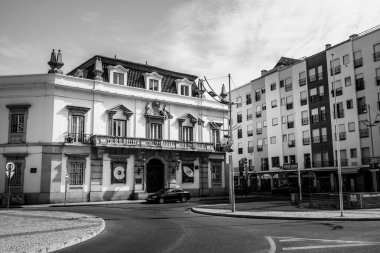 Algarve, Portekiz 2025.06.28 Pembe tişörtlü yaşlı bir adam Algarves 'in göbeğindeki mozaik kaplı bir alışveriş sokağının gölgesinde oturuyor.             