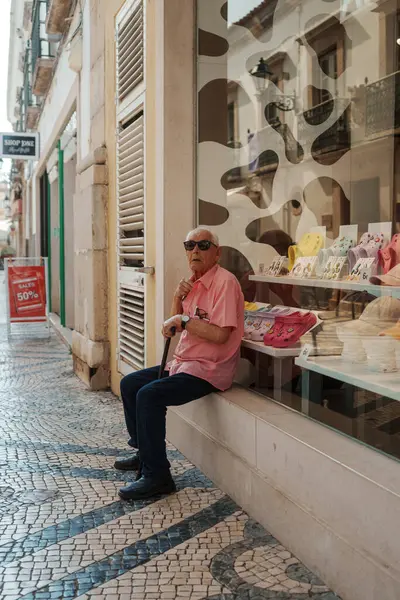 Tavira, Algarve, Portekiz 2025.07.02: Kemerli sütunlar, sallanan bayraklar ve güneşli ana meydanda çağdaş bir taş çeşme ile beyazlatılmış belediye binası                                                   