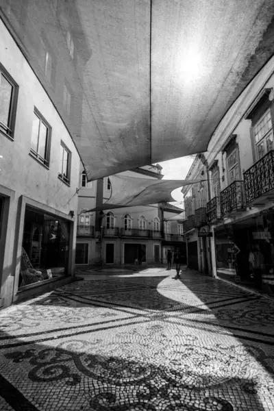 Tavira, Algarve, Portekiz 2025.07.02: Kemerli sütunlar, sallanan bayraklar ve güneşli ana meydanda çağdaş bir taş çeşme ile beyazlatılmış belediye binası                                                   