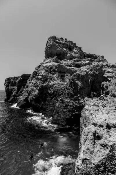 Tavira, Algarve, Portekiz 2025.07.02: Kemerli sütunlar, sallanan bayraklar ve güneşli ana meydanda çağdaş bir taş çeşme ile beyazlatılmış belediye binası                                                   