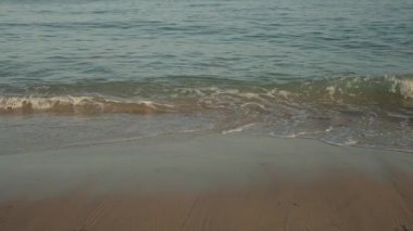 Algarve, Portekiz 2025.07.01 Yumuşak deniz dalgaları kumlu kıyıya yuvarlanarak, yumuşak doğal ışık altında su ve kum dokularını yakalıyor.. 