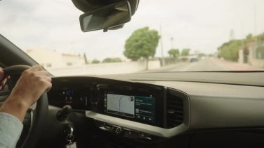 Algarve, Portekiz 2025.07.01 İç görünümü GPS navigasyon, hız göstergesi ve sürücülerin güneşli bir günde direksiyonda olduğu bir arabanın iç görünümü. 