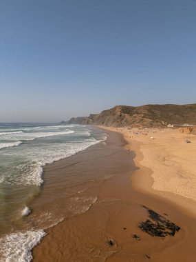 Vila do Bispo, Algarve, Portekiz 2025.07.01 Praia da Cordoama 'nın altın saatinde havadan görünüşü kıyıya vuran dalgalar ve uçurumlar. 