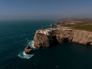 Sagres, Algarve, Portekiz 2025.07.03 Cape St. Vincent deniz fenerinin Atlantik kıyı şeridine bakan engebeli kayalıklardaki kırmızı kubbesi.. 
