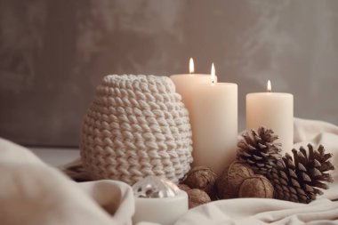 Kış kompozisyonu fotoğrafı mumları yaktı beyaz örgü süveter kozalakları ve pastel arka planda anason.