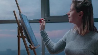 Yetenekli bir kadın sanatçı tuvale resim çizer. Çağdaş ressam modern soyut resim yaratıyor. Sanat terapisi. Genç kadın ressam akrilik boya kullanarak tuvale resim çiziyor. 4K, UHD. 