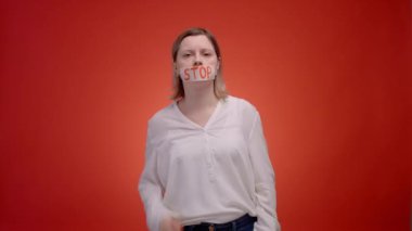 A woman with a closed mouth with tape, backing tape away screams. Stop being silent while youve been abused by someone, cry to get help. High quality 4k footage