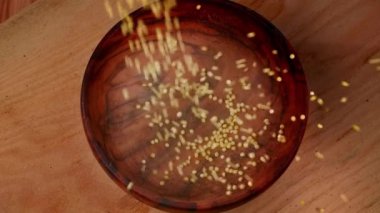 Millet kaseye düşüyor, sağlıklı besleniyor. Diyet, kinoa taneleri yemek için hazır. Yüksek kalite 4k görüntü