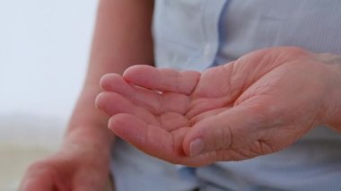 Şişeden hap alan yaşlı bir kadın el tüpten tabletleri düşürüyor. Antibiyotiklerle ilaç reçetesi