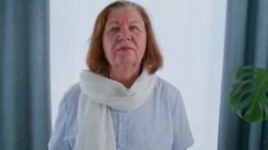 Yaşlı bir kadın yüzüne dokundu ve kaç tane kırışıklığı olduğunu değerlendirdi. Emeklilikten sonra yaşlanma süreci, tekrar güzel olmak için ameliyata hazırlanma. 