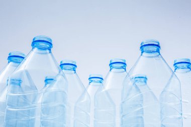 Mavi arka planda plastik şişeler ekolojik felaketlerin bir sembolü olarak veya sudan toplanan boş şişelerin geri dönüşüm için bir reklam olarak üretilmesi.