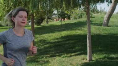 Olgun bir kadın parkta koşuyor ve göğsünde ağrı, 40 'lı yaşların başında kalp krizi geçiriyor. Kardiyoloji problemi ve spor aktivitesi