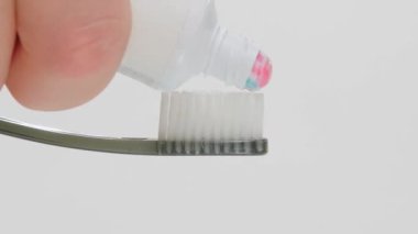 Diş fırçasını sıkan diş macununun süper yakın plan görüntüsü. Güzel sürgülü diş macunu. Beyaz dişler. 
