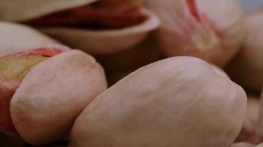 Dönen fıstıklara yakın çekim, fındık alerjisi teması. Fıstık içeren besin ve mikro elementler. Bira için atıştırmalık..