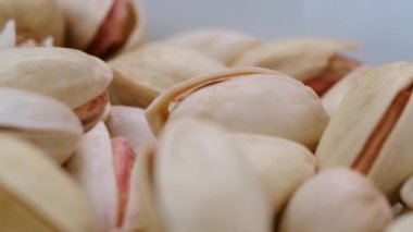 Dönen fıstıklara yakın çekim, fındık alerjisi teması. Fıstık içeren besin ve mikro elementler. Bira için atıştırmalık..