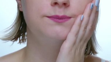 Dişi ağrıyan bir kadın dişini ağzından çıkarıyor, diş hastalığını kaybediyor. Kadınların ağzını kapat, üzgün yüz ifadesi, dişçiye git.