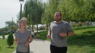 Kamu parkında koşan antrenör kadınla takıntılı bir adam kilo vermeye çalışıyor. Koç ve özel destekli sağlıklı bir yaşam tarzı.