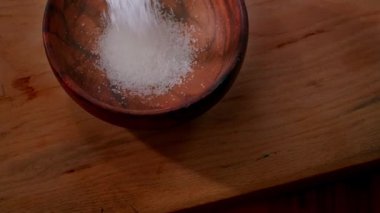 Şeker ağır çekimde ahşap kaseye düşüyor. Yemek pişirmek için malzemeler, yiyeceğe sağlıksız ilaveler. Şeker bağımlısı