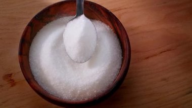 Kahveye ya da çaya eklemek için tahta bir kaseden kaşıkla şeker almak. Şeker bağımlılığı. Yüksek kalite 4k görüntü