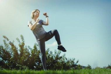Parkta boks yapan genç bir kadın, kendine güvenen bir kadın tüm sorunlarla savaşıyor. Sağlıklı yaşam tarzı ve günlük eğitim.