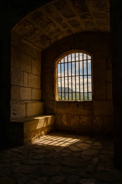 バーが付いている暗い刑務所の部屋は脱出を防ぐ スペインの城の冷たい塔 冷たい石壁 — ストック写真
