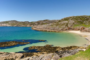 İskoçya 'nın güzel plajında kürek çeken insanlar var. Saf mavi sular Karayipler 'deki gibi.