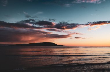 Uzak bir adada, açık denizde dramatik bir gün batımı. İskoçya Kuzey Sahili 500