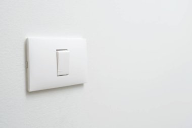 Turn off the light, close up female hand is closing the power switch. Save energy, reduce global warming.	