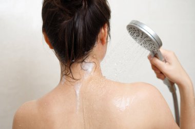 Kadın duş alıyor, banyoda banyo yapıyor.