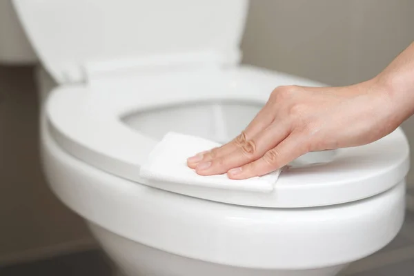 女人在家里用纸巾清洁卫生间 — 图库照片