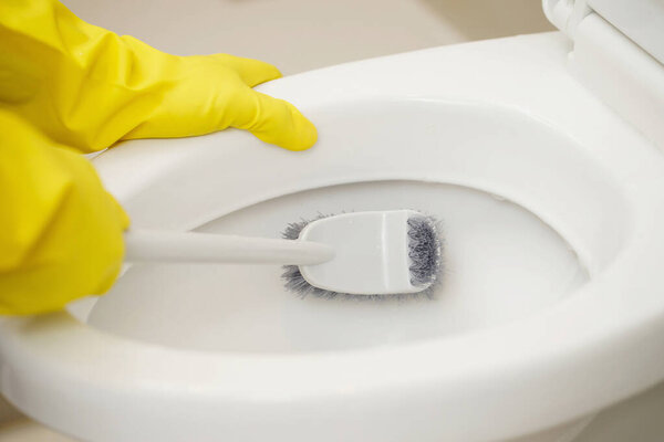 Housewives use brushes to clean the bathroom and take care of sanitary wares.