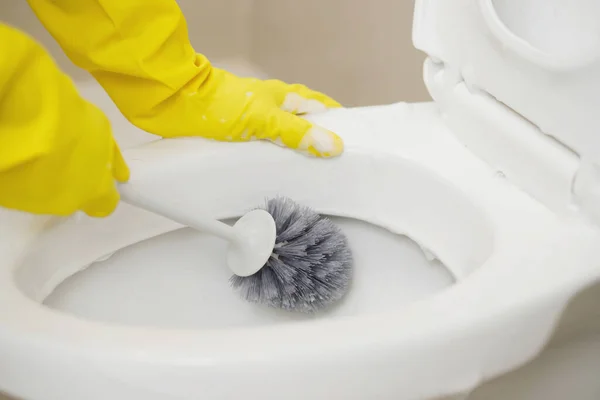 家庭主妇们用刷子来清洁浴室以去除污垢和照看卫生用品 — 图库照片