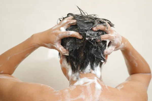 一个人用洗发水洗头发 — 图库照片