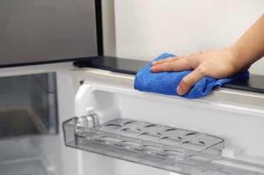 Çalışanlar buzdolabını temizlemek için bez kullanıyorlar..