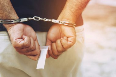Prisoner male criminal standing in handcuffs. banner copy space.  clipart
