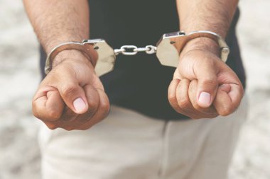 Elleri arkada kelepçelenmiş mahkum erkek suçlu. afiş kopyalama alanı. 