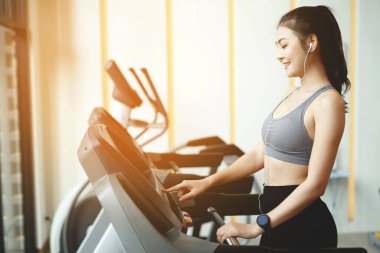Spor salonunda kilo vermek için egzersiz yapan Asyalı kadın.
