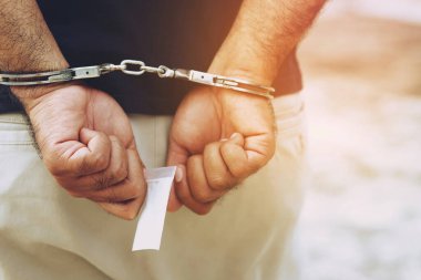Tutuklu erkek suçlu kelepçeli duruyor. afiş kopyalama alanı. 