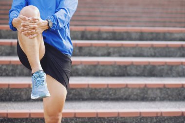 Genç koşucu, koşmadan ya da yolda çalışmadan önce ısınmak için esniyor. Koşu ve saha sporcusu egzersizi. Fitness ve spor sağlıklı yaşam tarzı konsepti. Boşluk afişini kopyala.