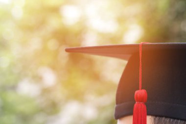Mezun olmayı kutluyorlar. Arka planda el ele tutuşmanın verdiği mutluluk şapkası ve diploma sertifikası. Mezuniyet günü üniversite diploması sırasındaki tebrik eğitimi. 