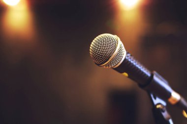 Konser salonunda ya da konferans odasında sahne ışıklarında mikrofonu kapat. Uzay afişini kopyala. yumuşak odak.