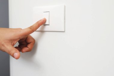 Işığı kapat, parmak adam eli enerji tasarrufu için evdeki duvarla güç düğmesini kapatıyor. Küresel ısınmayı azalt.