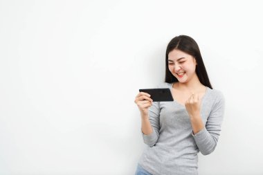 Model Asyalı kadın duyguları cep telefonlarında online piyango biletleriyle ödül kazanmaktan mutlu ve heyecanlı..