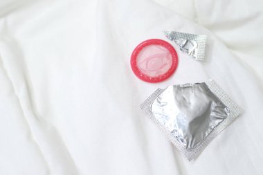 Kadın elinde kullanmaya hazır prezervatif, yatak enfeksiyonunu önlemek için kondom güvenli seks konsepti verir ve doğum oranını ya da güvenli prezervatifleri kontrol eder. Dünya AIDS Günü, 