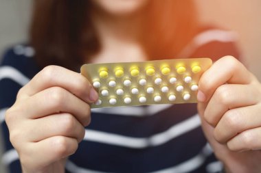 Kadın elleri elinde doğum kontrol hapları açıyor. Kontraseptif hap yemek. Kontrasepsiyon doğum ve gebelik kavramını azaltır.