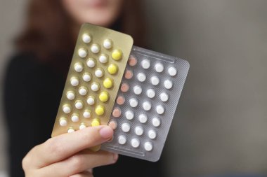 Close up Oral contraceptive pill on pharmacy counter with colorful pills strips. Contraception reduces childbirth concept.	